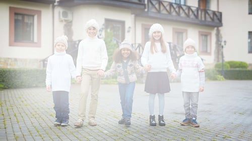 a group of children. The image looks faded and misty, as though a with a white cloud is in front of the children